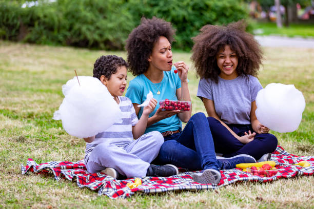 una famiglia afroamericana sta passando del tempo al sacco nella natura. - black cherries foto e immagini stock