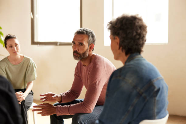 istock A therapy conductor is talking to a group of patients. 1324495951