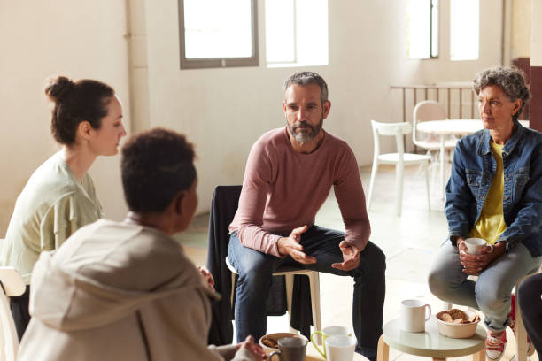 istock A group leader is coaching the team sitting in a circle. 1324495995