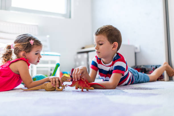 istock Children playing with toy dinosaurs 1324496011