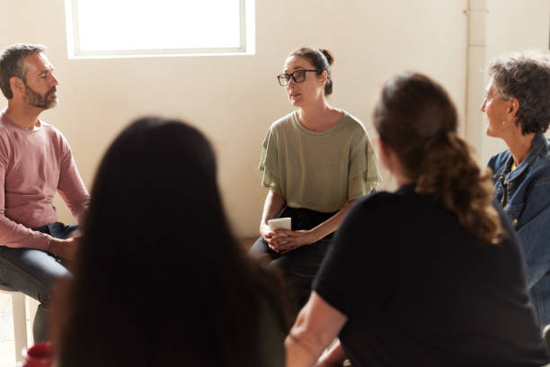 una donna triste sta parlando con gli altri membri del gruppo terapeutico. - discussion women circle therapy foto e immagini stock