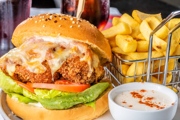 A chicken parma burger with lettuce and tomato