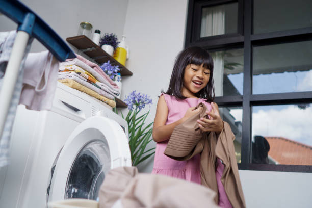 istock little asian girl doing laundry at home 1324496758