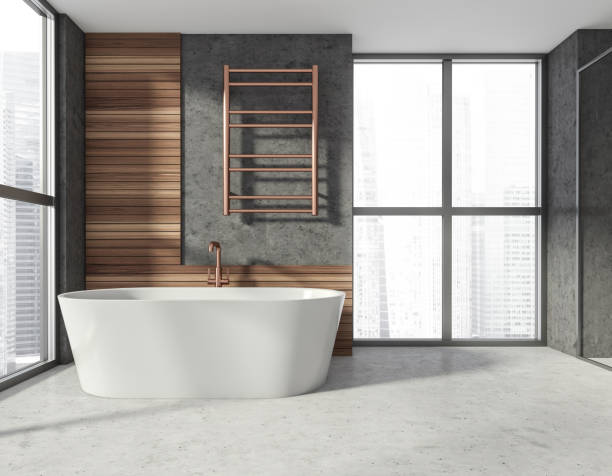 istock Modern stylish hotel bathroom interior, with ceramic bathtub. Grey wall, concrete floor. Panoramic window. City view. 1324501849