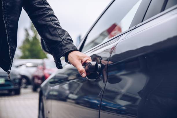 l’homme cherche la poignée de la porte de la voiture - location de voitures photos et images de collection