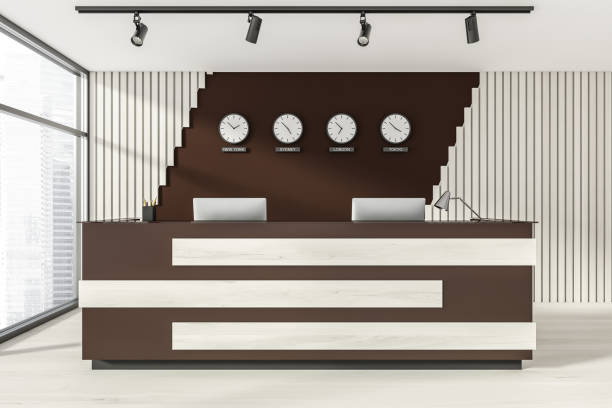 istock Empty office, wooden reception interior at white wall, 4 clocks on it. Panoramic window. Hotel check in desk. 1324501902