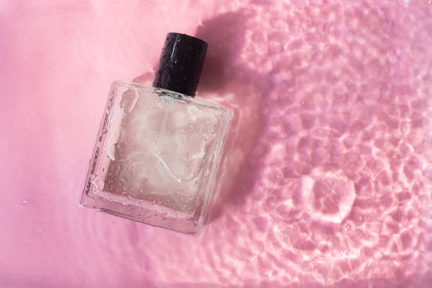 istock Perfume bottle on the background and water drops. A bottle of perfume without inscriptions . Smell. Perfume on a pink background. Water drops. Copy space. 1324502021