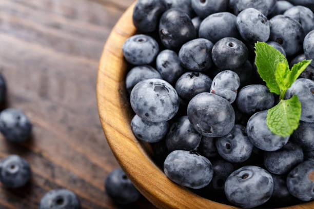 istock Freshly picked blueberries in a wooden bowl. 1324505009