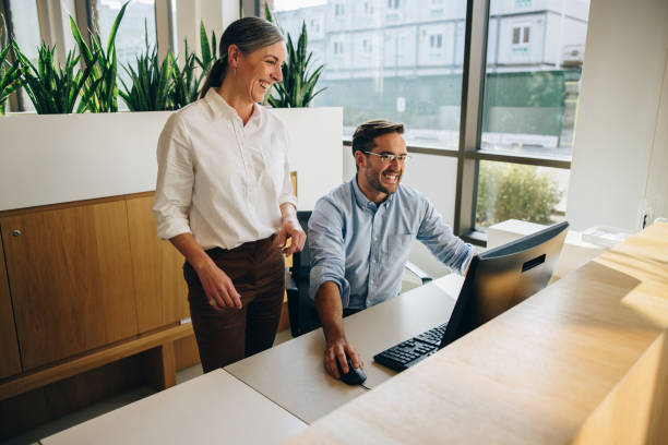 istock Manager standing by employee working in office 1324509516