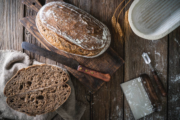 istock Sourdough bread loaf and Banneton basket in bakery on wooden rustic table 1324511326