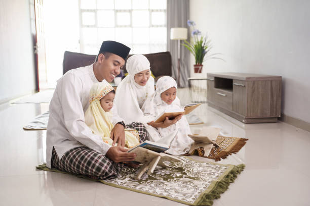 happy muslim family with children reading quran and pray together portrait of happy muslim family with children reading quran and pray together at home father allah stock pictures, royalty-free photos & images