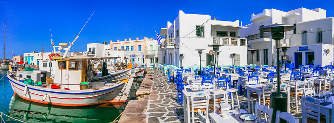 Greece travel. Cyclades, Paros island. Charming fishing village Naoussa. view of port with street bars and restaurants (taverns) by the sea.