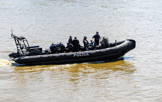 London, United Kingdom - May 30 2021:  A Police boat heading along the River Thames photographed from Thames Path