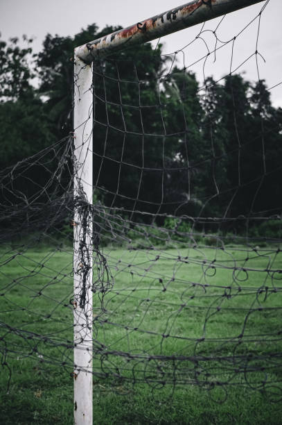 istock Goalposts on a football field with a broken net 1324519606