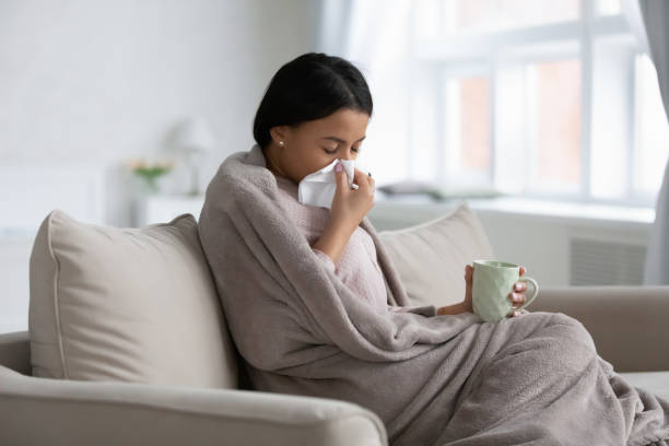 istock Frustrated sick mixed raced woman wrapped in warm blanket 1324522224