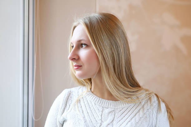 istock Beautiful blonde girl thoughtfully look out window 1324524769