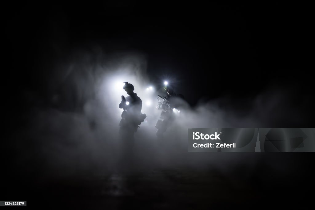 Anti-riot police give signal to be ready. Government power concept. Police in action. Smoke on a dark background with lights. Blue red flashing sirens. Dictatorship power Anti-riot police give signal to be ready. Government power concept. Spec ops police in action. Smoke on a dark background with lights. Blue red flashing sirens. Selective focus Special Forces Stock Photo