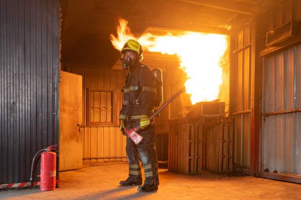 istock A firefighter or fireman with uniform using water fire hose against hot burning fire and dangerous smoke in the container, an emergency accident rescue. People. Hero 1324526266