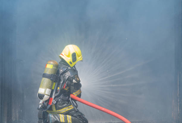 istock A firefighter or fireman with uniform using water fire hose against hot burning fire and dangerous smoke in the container, an emergency accident rescue. People. Hero 1324526275