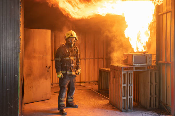 istock A firefighter or fireman with uniform using water fire hose against hot burning fire and dangerous smoke in the container, an emergency accident rescue. People. Hero 1324526283