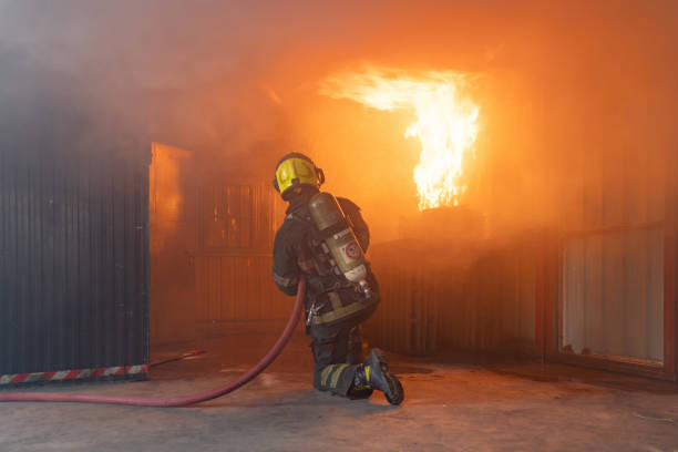 istock A firefighter or fireman with uniform using water fire hose against hot burning fire and dangerous smoke in the container, an emergency accident rescue. People. Hero 1324526308
