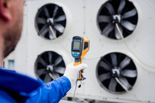 istock Technician uses a thermal imaging infrared thermometer to check the condensing unit heat exchanger. 1324528795