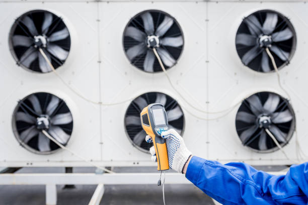 istock Technician uses a thermal imaging infrared thermometer to check the condensing unit heat exchanger. 1324528986