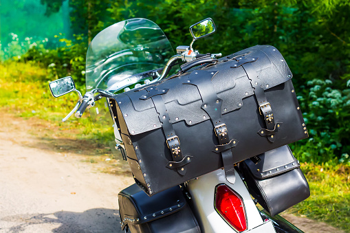 Leather motorcycle bag close-up. Travel by moto on a sunny summer day. Luggage system for motorcycles.