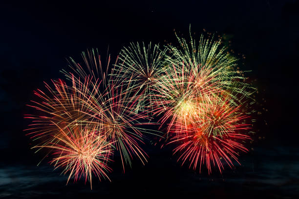 istock Bright colored fireworks on black background. Celebration and holidays concept. New Year, Independence Day, July 4 Festival. Bright explosions of lights in the sky. 1324529372