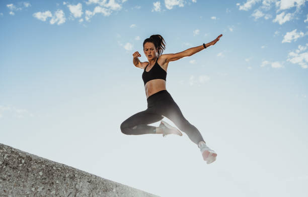 istock Fitness woman jumping from wall 1324529701