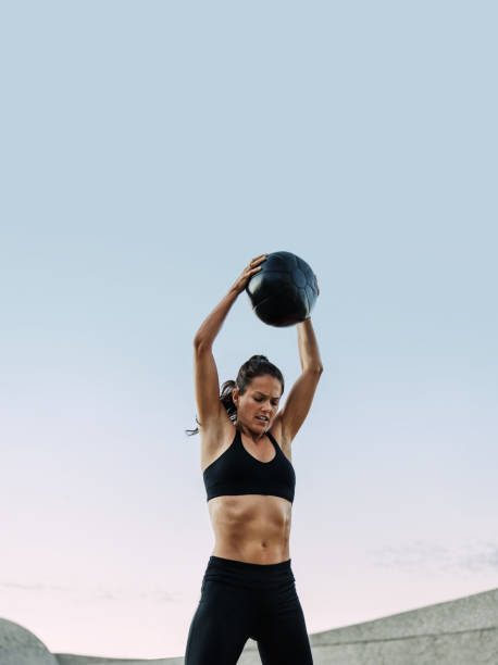 istock Fitness woman doing exercises using a medicine ball 1324529716