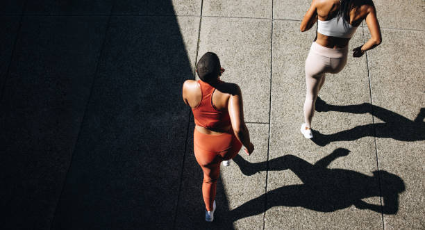 istock Female friends running together 1324529727