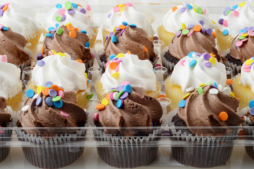 closeup mini chocolate and vanilla cupcakes with confetti sprinkles