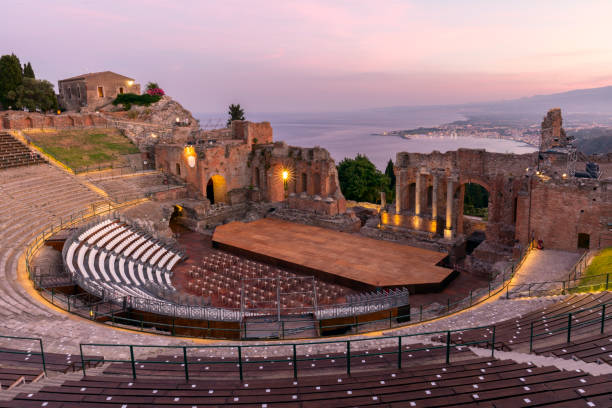 pôr do sol no antigo anfiteatro romano-grego com a baía de giardini naxos nas costas em taormina, sicília, itália - sicily taormina mt etna italy - fotografias e filmes do acervo