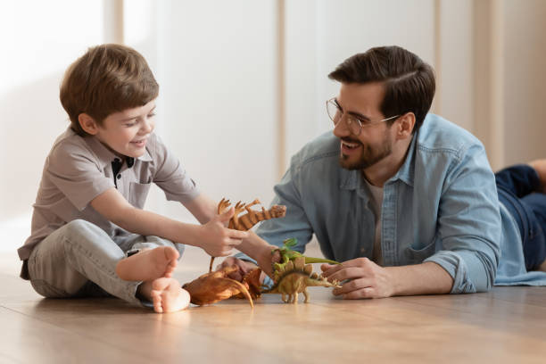 istock Happy dad play toy figure with small son 1324531998