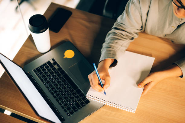 istock Young woman studying online courses with a laptop, notebook and coffee 1324534503