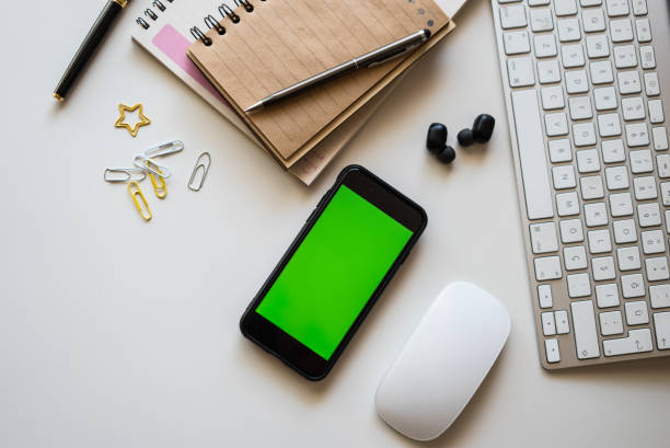 istock home office set up mouse keyboard notepads mobile phone with green screen earphone and pens  are on the white table horizontal photograpy 1324536617