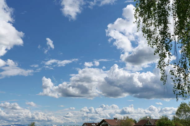 Bavaria, Germany. Panoramic view of our village with characteristic Bavarian white and blue cloudy sky and the alps at the background.