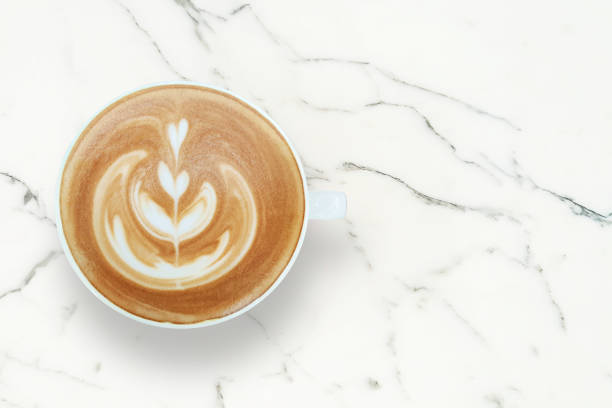 istock Cup of Cappuccino with Latte Art on White Marble Table Background, Top View with Copy Space 1324538138