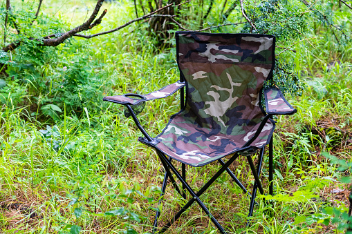 camouflage camping chair on grass background