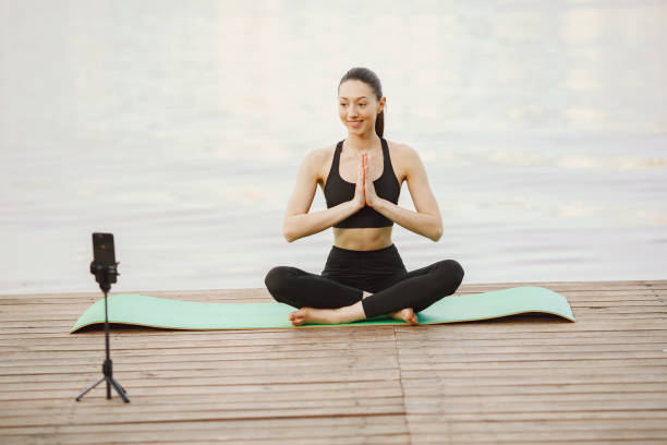 istock Bloger practicing advanced yoga by the water 1324539188