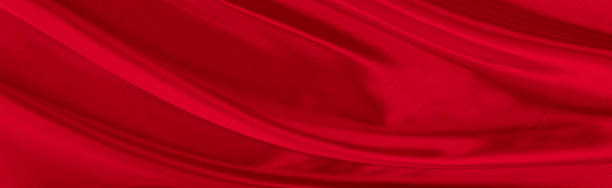 istock Black red satin dark fabric texture luxurious shiny that is abstract silk cloth background with patterns soft waves blur beautiful. 1324540103