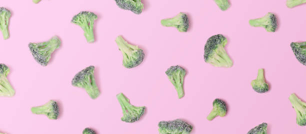 istock Deep frozen broccoli on a pink background. Top View 1324546545