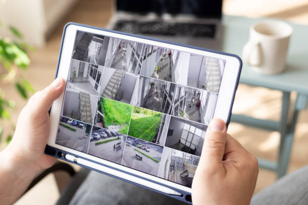 mann überwacht moderne cctv kameras auf digitalen tablet sinnen innen - überwachungskamera stock-fotos und bilder