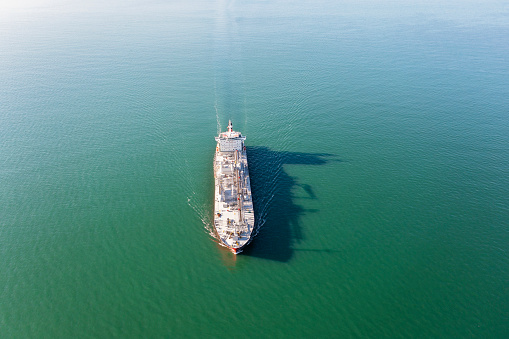 Aerial view of a tanker ship traveling over open ocean in a clear day.