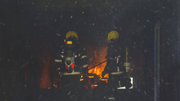 istock A group of firefighter or fireman with uniform using water fire hose against hot burning fire and dangerous smoke in the container, an emergency accident rescue. People. Hero teamwork. 1324550537