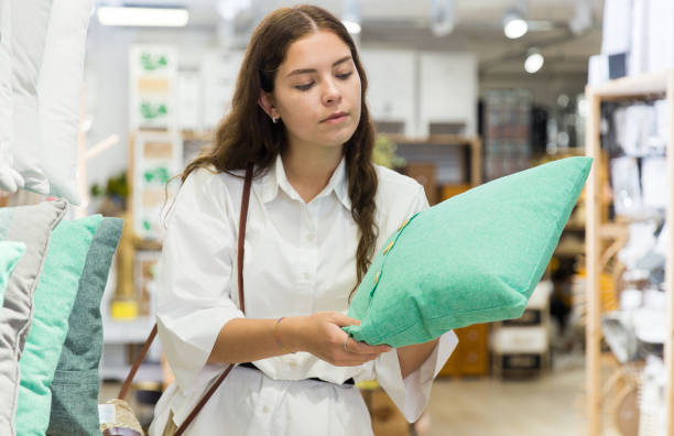 istock Woman choosing pillow in home textile shop 1324553514