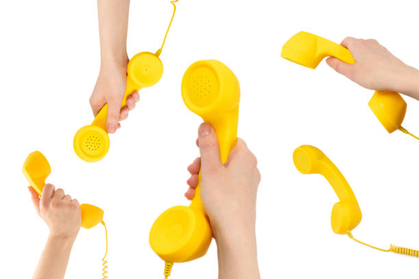 Yellow handset in woman hand isolated on white. Copy space.
