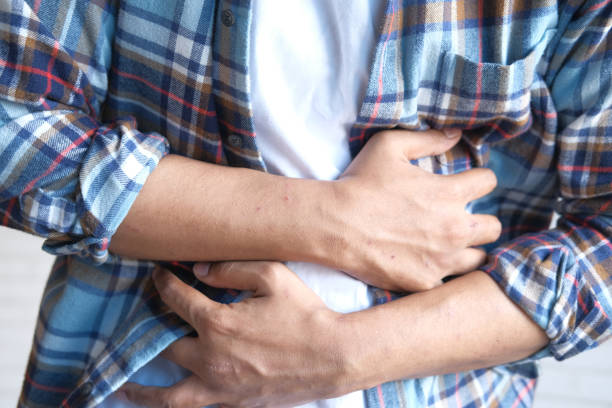 istock young man suffering stomach pain close up. 1324556465