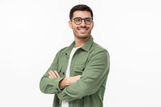 confident young man in casual green shirt looking away, standing with crossed arms isolated on gray - adamlar stok fotoğraflar ve resimler